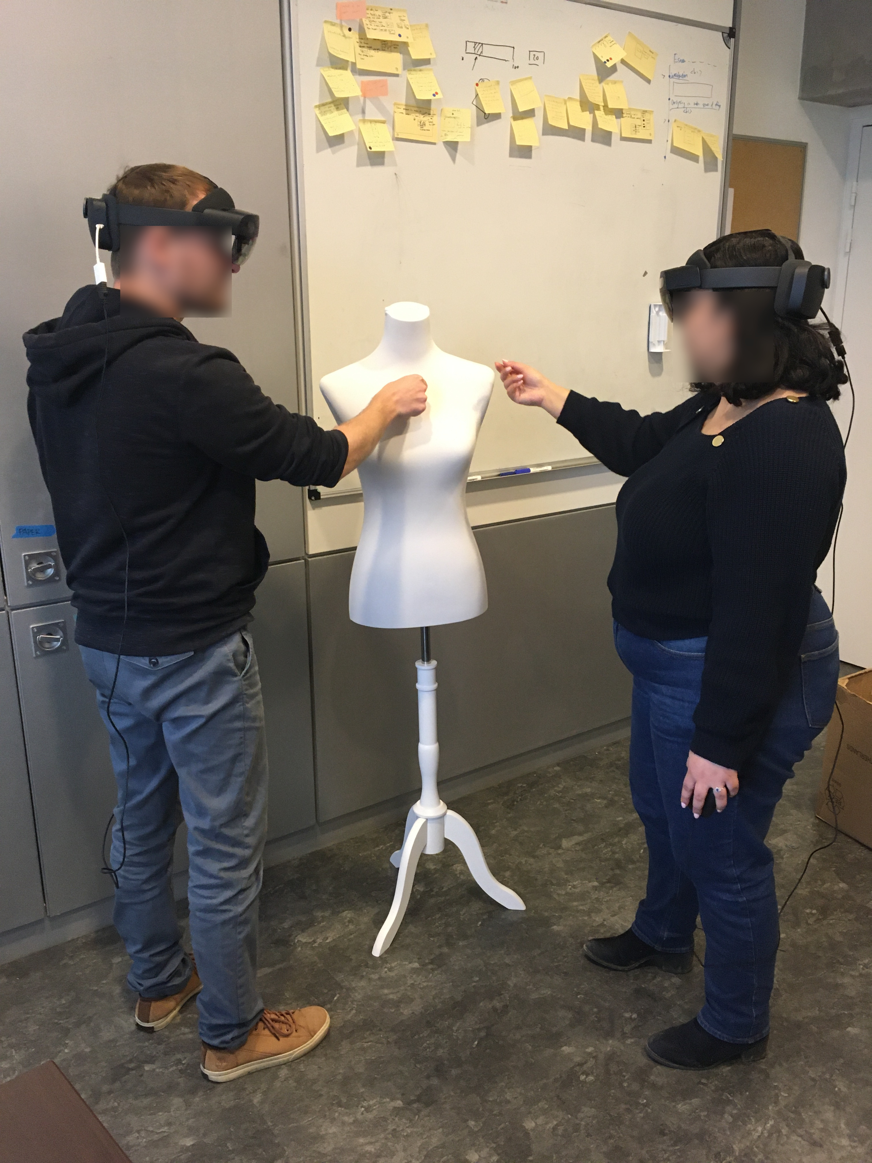 Two collaborators with AR headset working around a sewing mannequin.